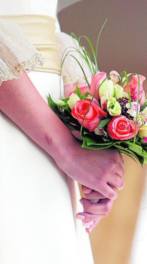 Una novia sujeta su ramo de flores durante la celebración de su matrimonio.