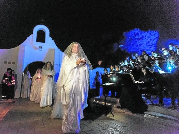 Varias actrices del Grupo de Teatro San Javier caracterizadas de espectros hacen su entrada en el cementerio, acompañadas por las voces del Orfeón Fernández Caballero, el pasado sábado.
