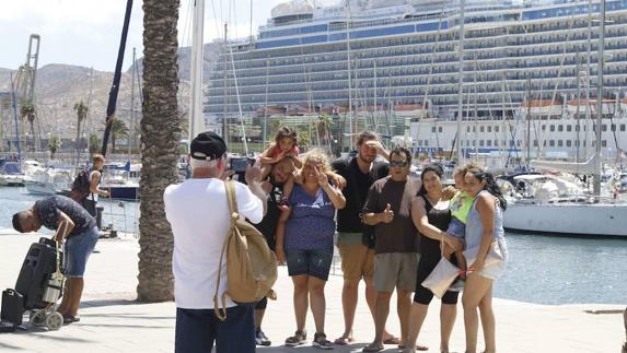 Unos turistas se hacen una foto frente a un crucero en Cartagena. 