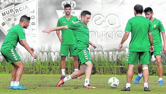 Titi, en el centro, persigue el balón en un entrenamiento del Real Murcia.