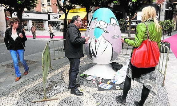 Salvador Torres pintando un huevo en la plaza Esteve Mora.