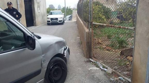 Un agente examina el coche tras empotrarse contra el muro. 