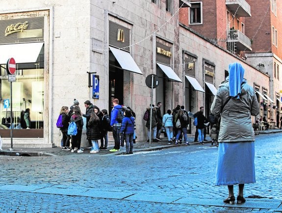 Una monja observa a varios jóvenes a las puertas del polémico McDonald's. 