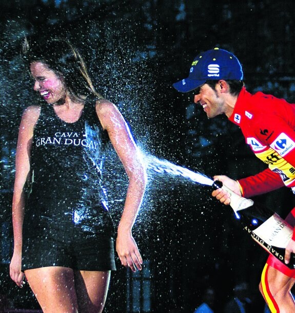 Alberto Contador lanza champán a una azafata para festejar su victoria en la 69 edición de la Vuelta a España, hace dos años, en Santiago de Compostela.