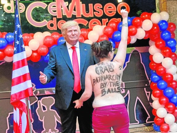 La activista de Femen echa mano a los atributos de la figura de cera de Trump, en Madrid. 