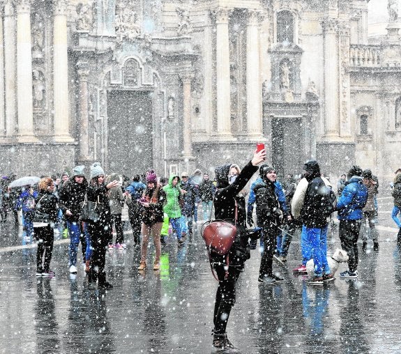 Una mujer se toma un selfi en la plaza de Belluga cuando arreciaba ayer la nevaba. 