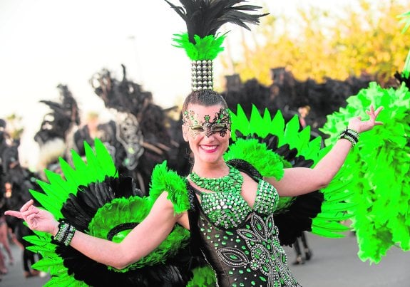 Llamativo traje con plumas y pedrería exhibido por una de las componentes de la comparsa Las Divinas.