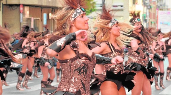 Una de las peñas foráneas participantes en el concurso desfila, ayer, antes del aguacero.