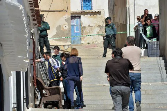 Familiares del difunto observan el traslado del detenido para el registro de su vivienda. 