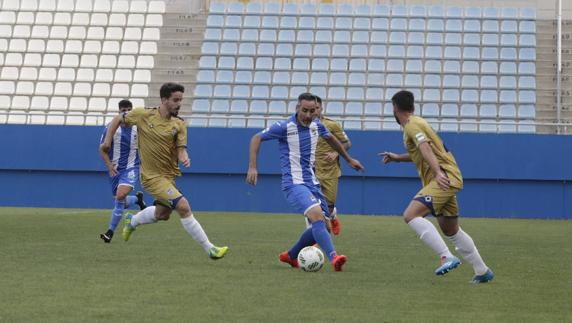 Abel, entre tres jugadores del Recre. 