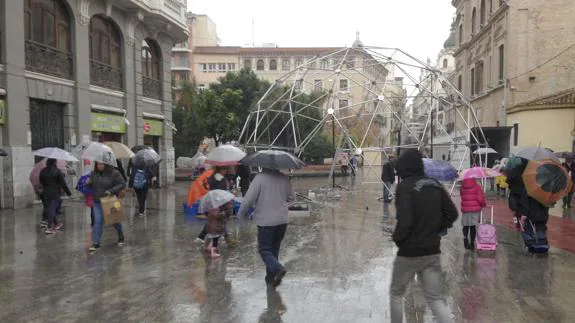 Viandantes por Murcia con paraguas.