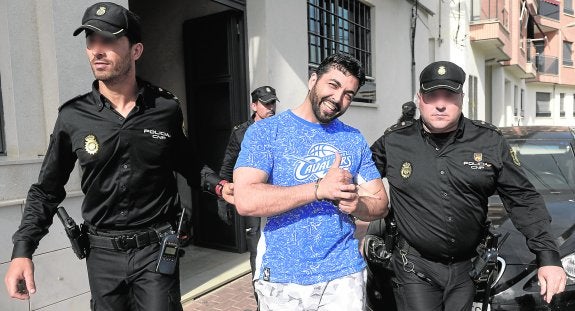 Pedro S. G., 'el Karateca', ayer, custodiado por dos policías nacionales tras el registro de su domicilio en Puebla de Soto. 