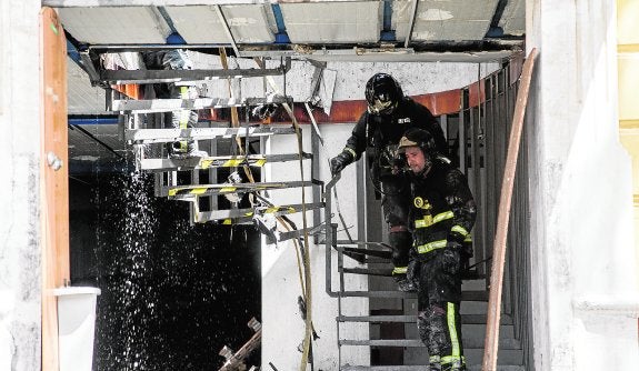 Dos bomberos, durante la extinción del incendio en la nave de Santa Lucía. :: j. m. rodríguez / agm