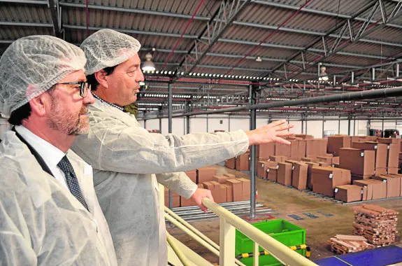 López y Sandoval, mirando las cajas en el almacén de Saeco. :: upct