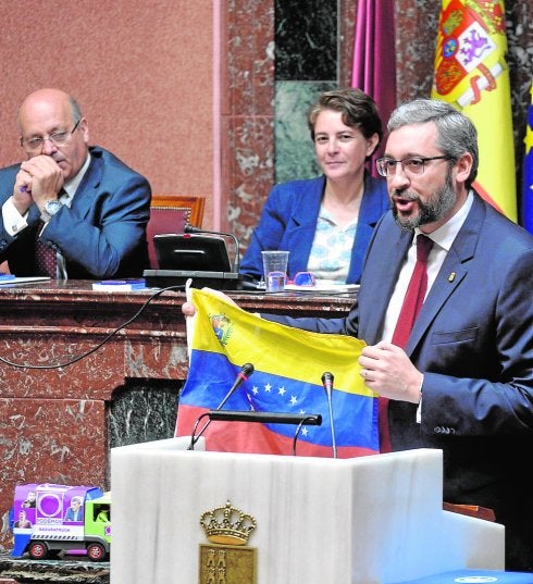 Martínez, con la bandera venezolana y el camión de la basura de Podemos.
