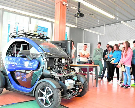 Visita de futuros alumnos y familiares a las instalaciones de la Universidad Politécnica de Cartagena; en la imagen, observan un vehículo sin conductor desarrollado por la UPCT.
