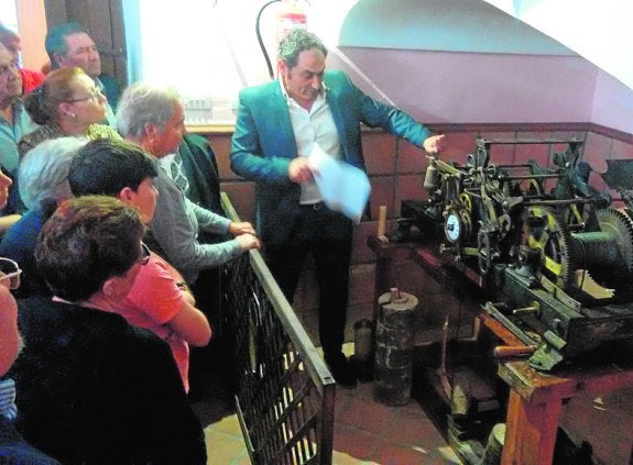 Vecinos contemplan la maquinaria del reloj.