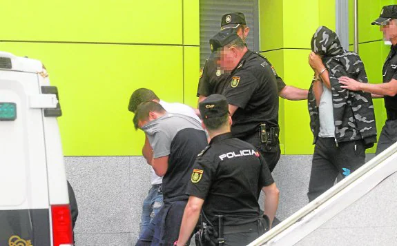 Tres detenidos se cubren el rostro, durante su traslado desde la Comisaría al juzgado.