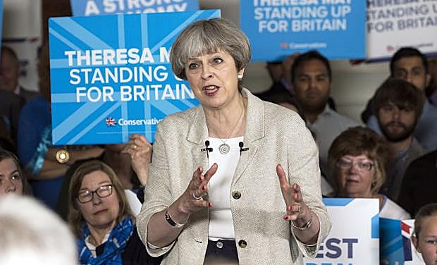 La primera ministra británica y líder del Partido Conservador, Theresa May (c).
