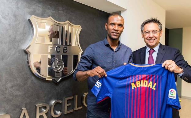 Eric Abidal posa junto a Josep Maria Bartomeu. 