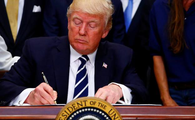 Trump firma un documento en la Casa Blanca. 