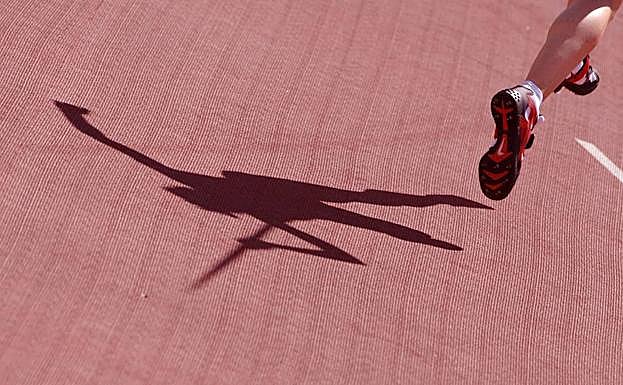 La sombra de un lanzador de jabalina se refleja en la pista. 