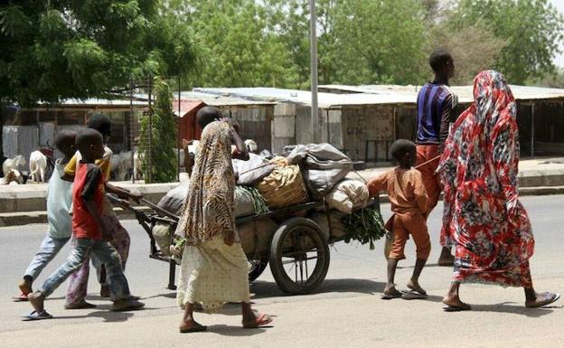 Varias personas avanzan con sus pertenencias en Borno. 