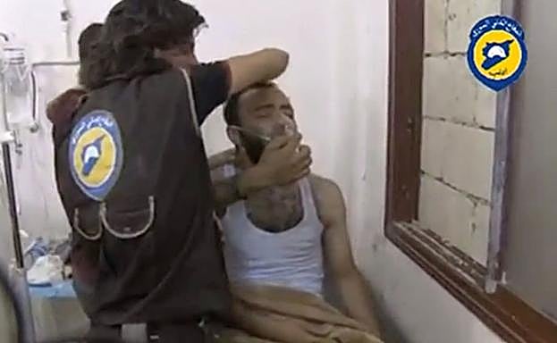 Captura de un hombre atendiendo a un herido tras un ataque químico en Idlib.