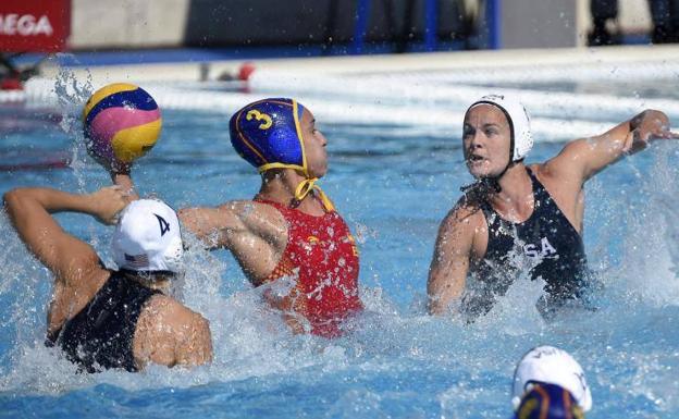 La waterpolista española Anna Espar Llaquet (c) trata de lanzar el balón ante la defensa de las estadounidenses . 