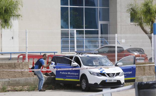 Agentes inspeccionan el lugar donde un hombre hirió con un arma de fuego a dos policías locales. 