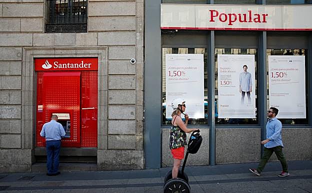 Un cajero del Santander junto a una oficina del Popular.