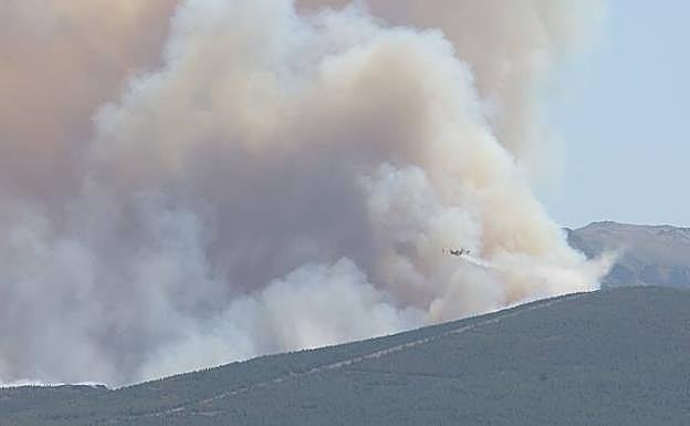 Un helicóptero trata de socorrer el fuego.