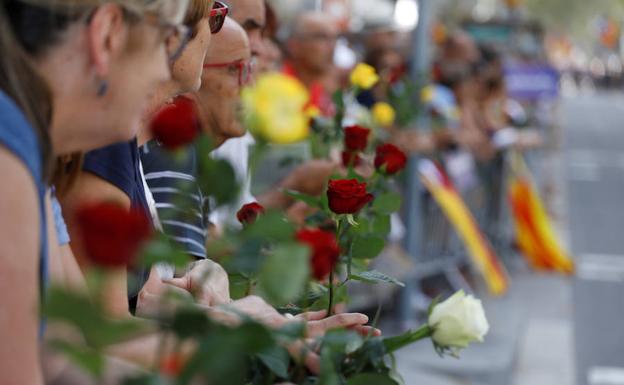 Rosas y carteles inundan el paseo de Gràcia contra el terrorismo.