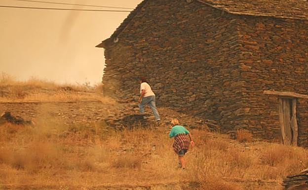 Dos vecinas tratan de escapar del fuego.
