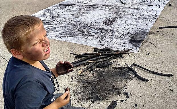 Un pequeño se suma a la elaboración del mural. 