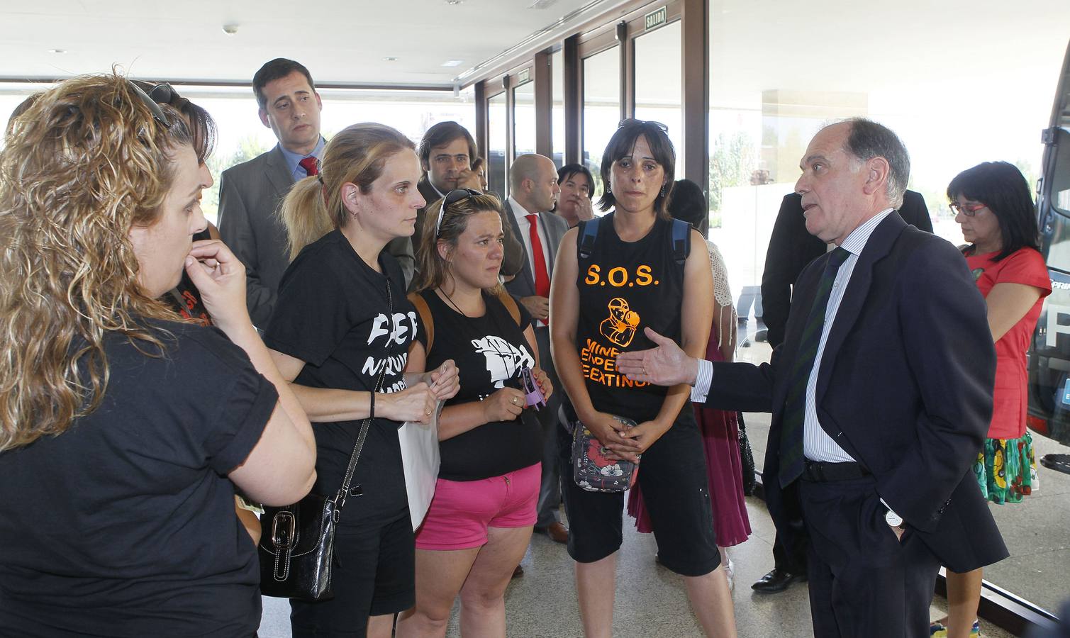 17.07.12 El consejero de Economia, Tomás Villanueva, dialoga, en el vestibulo de las Cortes, con cinco mujeres de mineros leoneses en el Debate sobre el Estado de la Región.