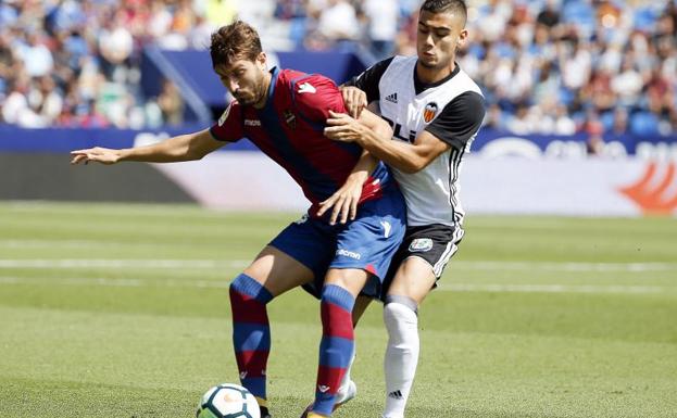 El centrocampista del Levante, José Gómez Campaña (i), controla la pelota ante el centrocampista del Valencia, Andreas Pereira (d).
