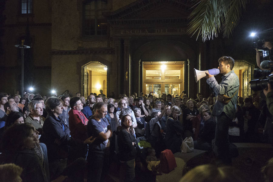 Un manifestantes arenga a un grupo de personas concentradas a través de un megáfono.