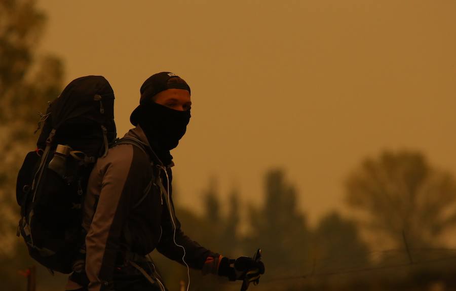 Un peregrino se tapa la cara debido al intenso humo existente en Ponferrada 