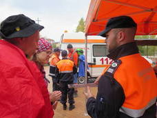 Un voluntario de Protección Civil atiende a dos peregrinos. 