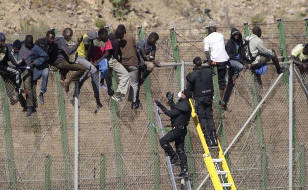 Inmigrantes intentan cruzar la valla de Melilla.