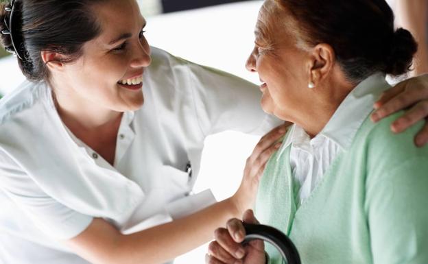 Enfermera atiende a una anciana en un hospital. 