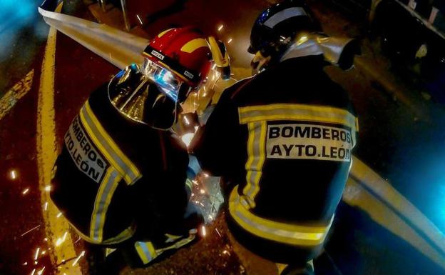 Dos efectivos de Bomberos cortando el guardarraíl. 