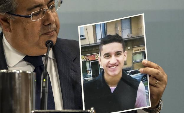 Juan Ignacio Zoido, ministro del Interior, en rueda de prensa con una foto del presunto autor del ataque yihadista de Las Ramblas Younes Abouyaaqoub. 
