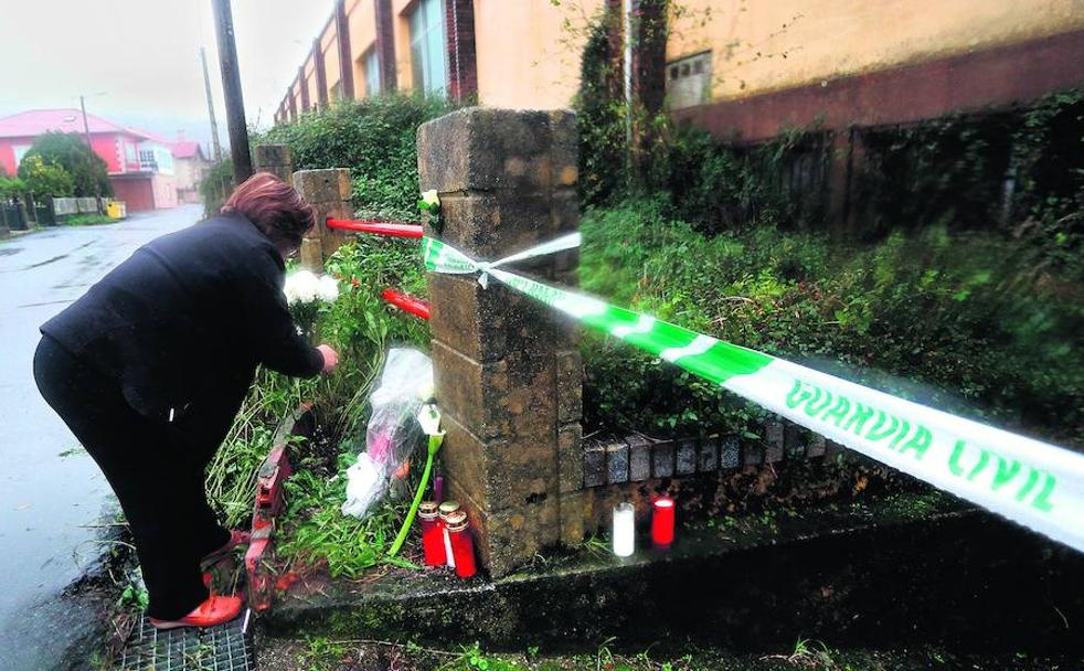 Una mujer deposita unas flores en homenaje a Diana Quer ante el pabellón donde permaneció escondido el cuerpo de la joven desde su asesinato.