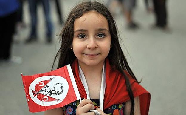 Una niña posa con una banderola adornada con la imagen de Mustafa Kemal Ataturk, fundador del estado moderno de Turquía. 