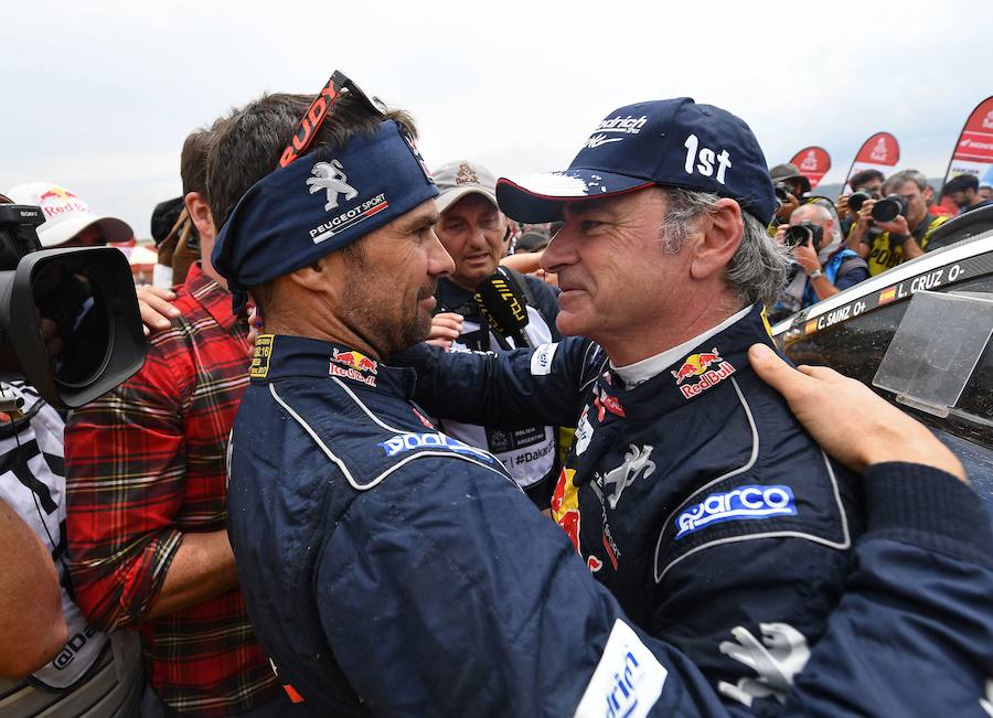 Cyril Despres felicita a su compañero de equipo, Carlos Sainz, por su triunfo.