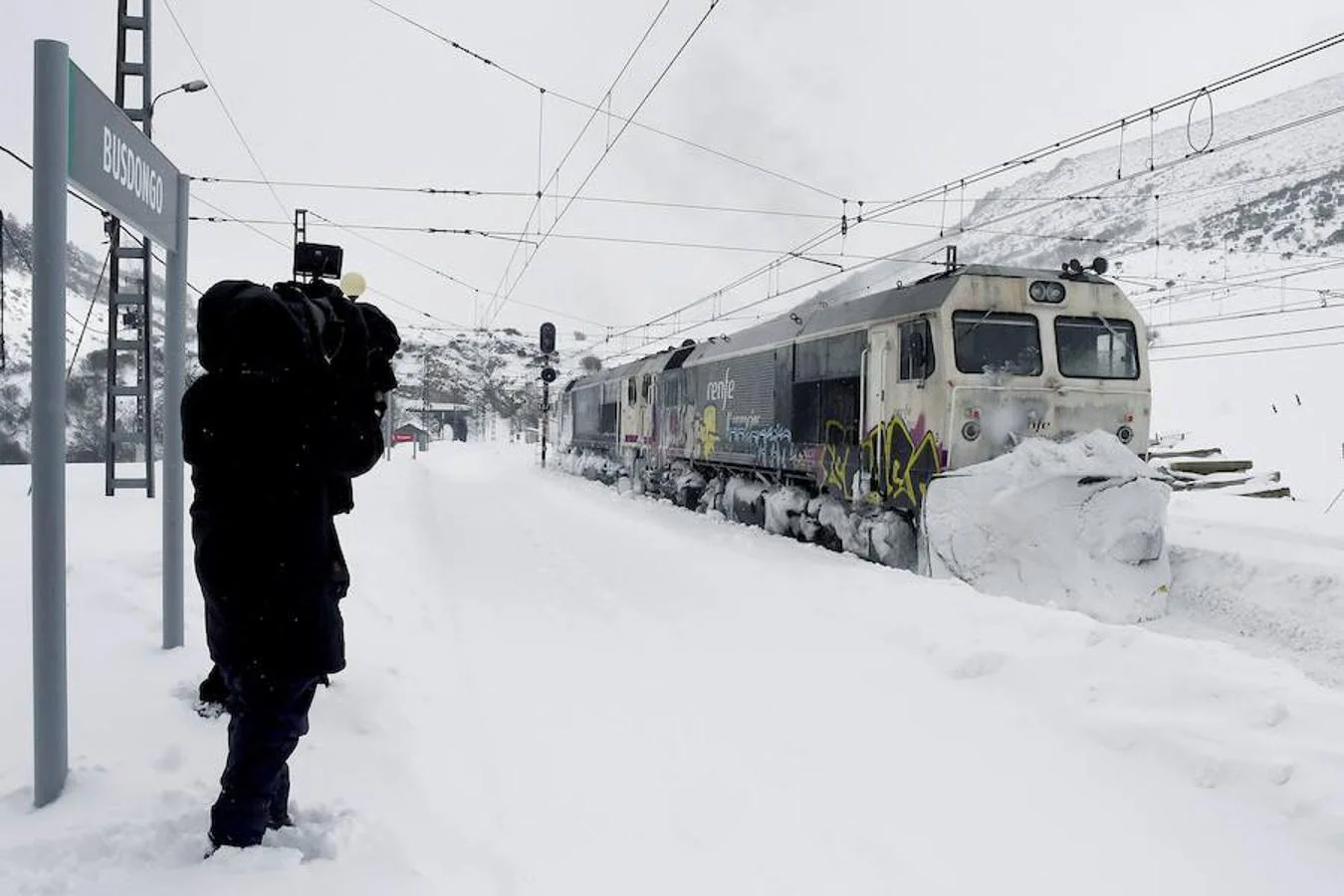 La vía férrea que une León y Asturias, afectada por la nieve. En la imagen, un tren parado en la estación de Busdongo (León) || La nieve frena al tren en el Puerto de Pajares. Las intensas nevdas están frenando en seco el tráfico ferroviario