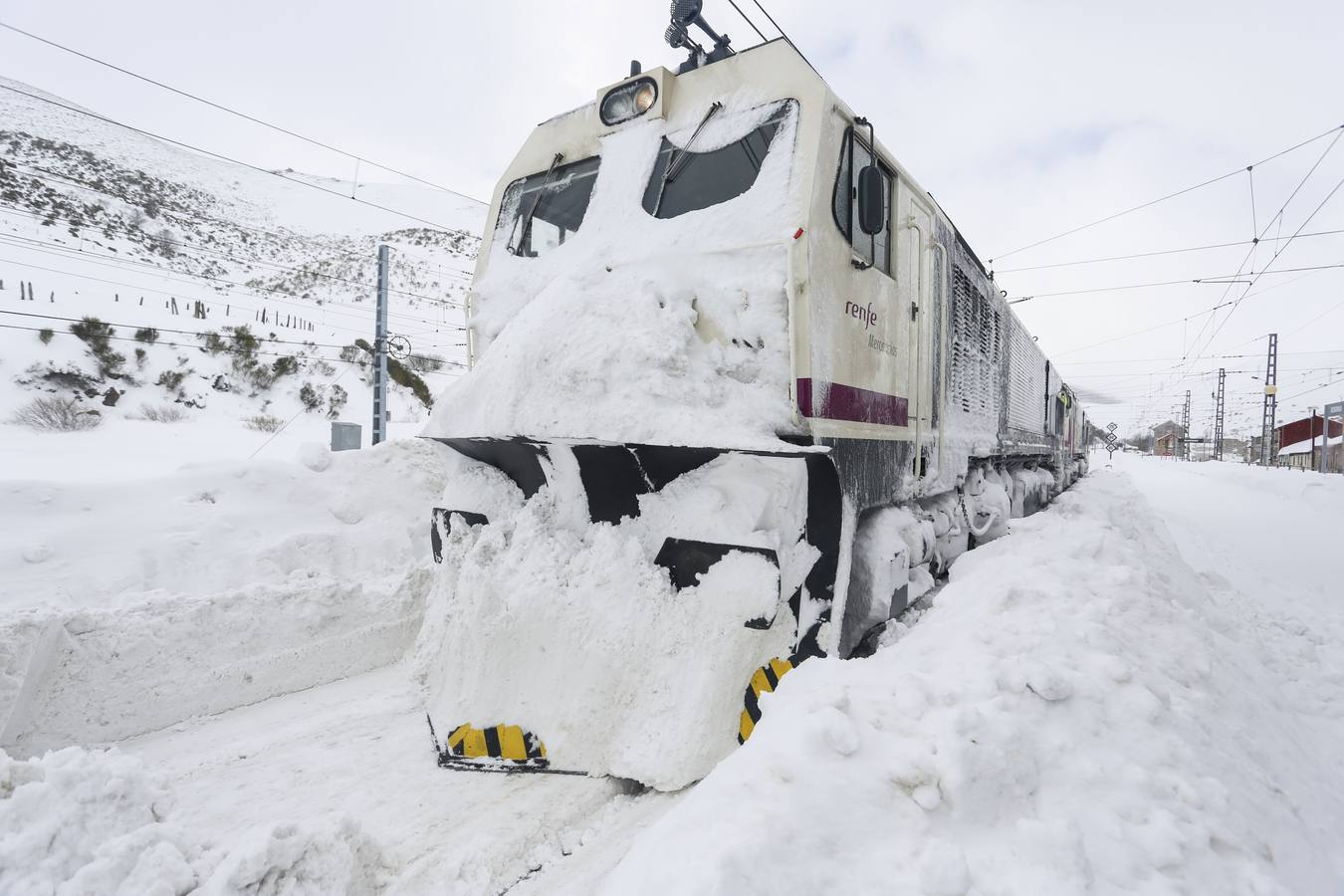 La vía férrea que une León y Asturias, afectada por la nieve. En la imagen, un tren parado en la estación de Busdongo (León).