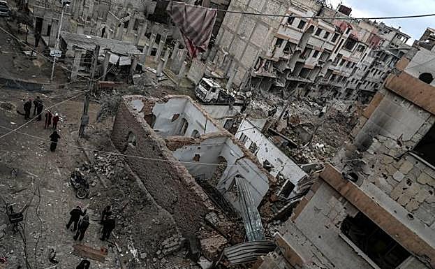 Vecinos inspeccionan los edificios en ruinas después de varios bombardeos en Duma, feudo rebelde de Guta Oriental (Siria).